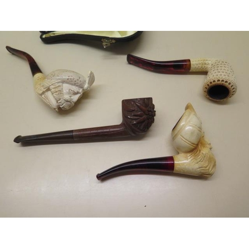 439 - A collection of four pipes to include two Meerschaum Turkish head pipes, a cased pierced reticulated... 