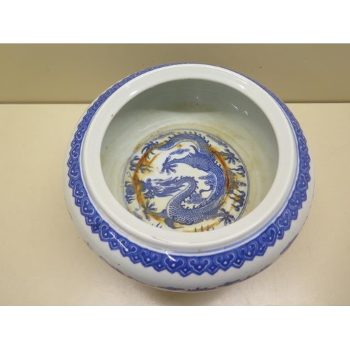 444 - An oriental blue and white dragon bowl on a hardwood stand, total 14cm tall x 22cm diameter, no obvi... 