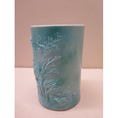 454 - A Chinese 19/20th century brush pot with a moulded landscape scene covered in a turquoise glaze, rai... 