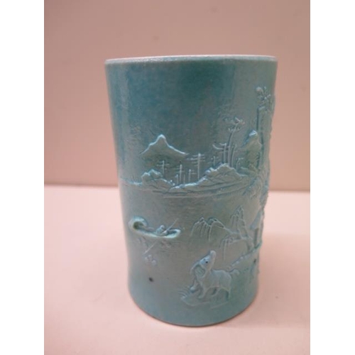 454 - A Chinese 19/20th century brush pot with a moulded landscape scene covered in a turquoise glaze, rai... 