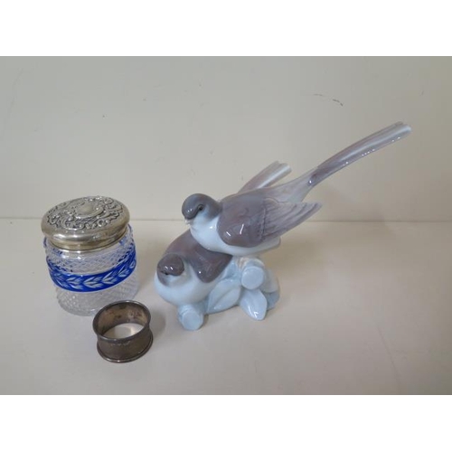 462 - A silver top bottle and a silver napkin ring and a Lladro bird group, bottle has a chip to base othe... 