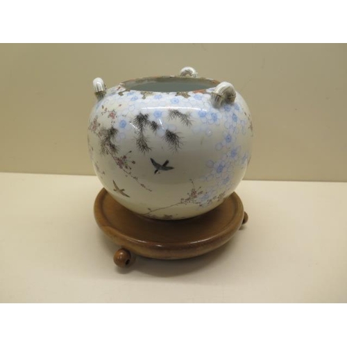 527 - An Oriental globe shaped hanging bird and prunus decorated censor on a turned wooden stand, globe 20... 