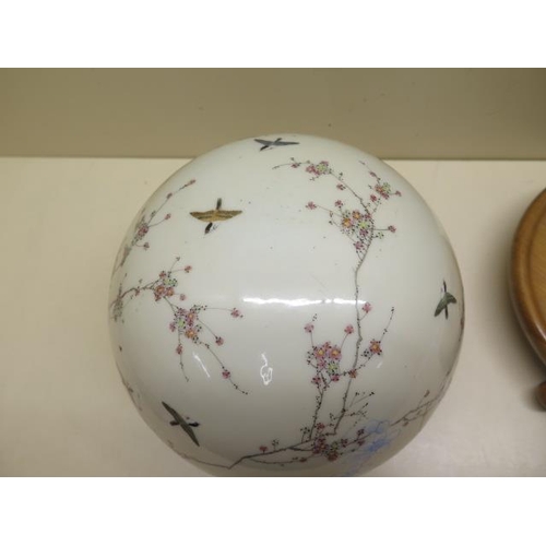 527 - An Oriental globe shaped hanging bird and prunus decorated censor on a turned wooden stand, globe 20... 