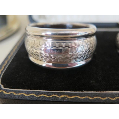 602 - A pair of lined silver napkin rings boxed and a pair of silver rimmed wine coasters, no engraving, s... 