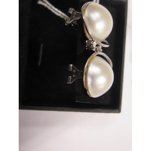 711 - A pair of 18ct white gold diamond and pearl earrings, 22mm wide, approx 15.8 grams, in good conditio... 