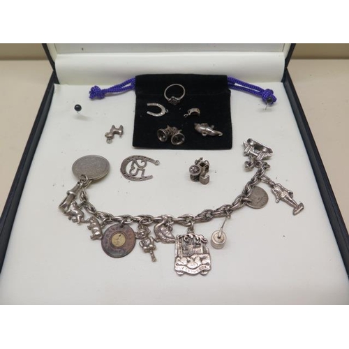 719 - A silver charm bracelet with spare charms and a non silver coin, approx 2.2 troy oz, bracelet is 20c... 