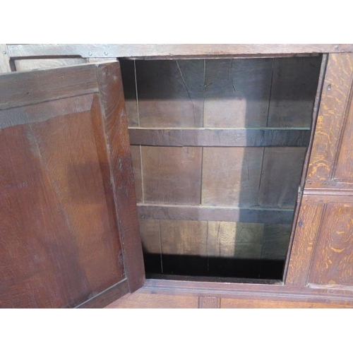 73 - An 18th century oak panelled cupboard with a single central door, 148cm tall x 117cm x 50cm, some la... 