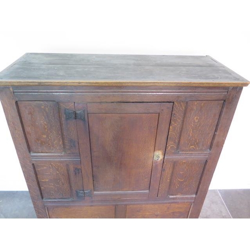 73 - An 18th century oak panelled cupboard with a single central door, 148cm tall x 117cm x 50cm, some la... 