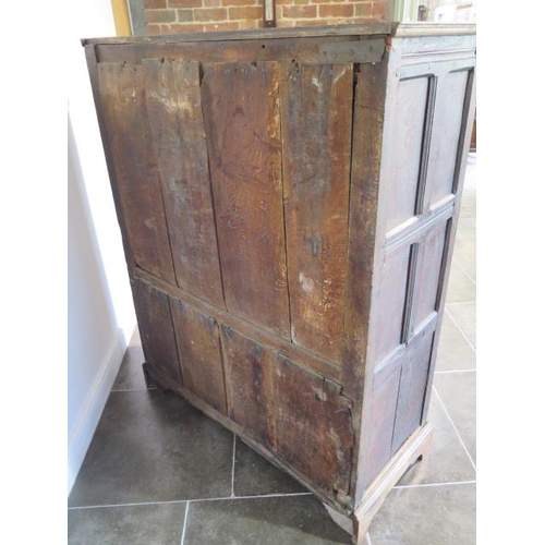 73 - An 18th century oak panelled cupboard with a single central door, 148cm tall x 117cm x 50cm, some la... 