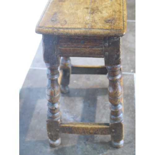 76 - An 18th century oak joint stool, 57cm tall x 45cm x 27cm, with wear consistent with age and later re... 