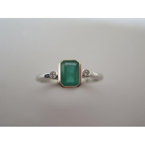 762 - A 9ct hallmarked white gold emerald and diamond ring, size O/P, emerald approx 4mm x 6mm, in good co... 