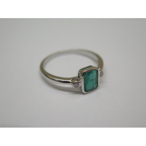 762 - A 9ct hallmarked white gold emerald and diamond ring, size O/P, emerald approx 4mm x 6mm, in good co... 