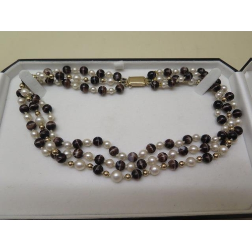 767 - A tiger eye, pearl and gold bead three strand necklace with a 9ct gold clasp, 38cm long, in good con... 