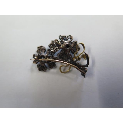 825 - A gold and silver diamond floral brooch pin, tests to approx 18ct, 4cm long, with two central diamon... 