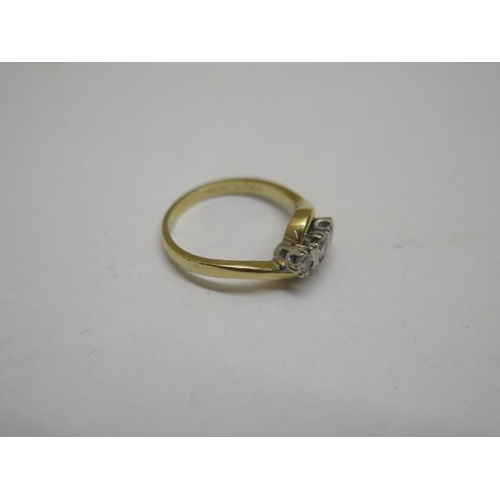 851 - A hallmarked 18ct yellow gold three stone diamond crossover ring, size K, approx 3 grams, some wear ... 