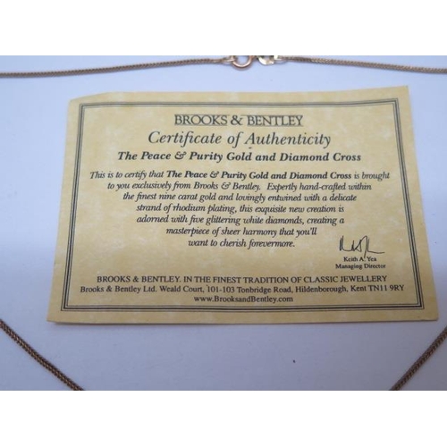 860 - A Brooks and Bently Peace and Purity 9ct yellow gold diamond cross on chain, and a 9ct 52cm chain, t... 