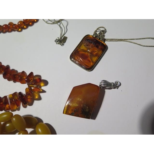 947 - A collection of seven burnt amber and amber type necklaces, one with a micro mosaic pendant and two ... 