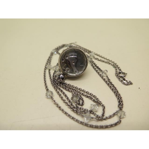 962 - A white metal pendant watch and chain, the dial detailed E GUBELIN, moisture to interior glass