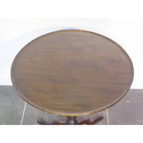 97 - A Georgian mahogany tripod wine table circular top with raised lip over a slim turned column and cab... 