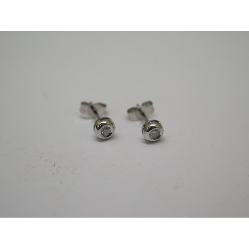 744 - A pair of 9ct white gold and diamond stud earrings, each approx 0.06ct