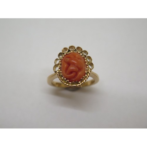 868 - A 22ct yellow gold ring with carved coral centrepiece, size N/O, approx 8.9 grams in good condition