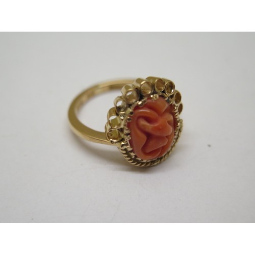 868 - A 22ct yellow gold ring with carved coral centrepiece, size N/O, approx 8.9 grams in good condition