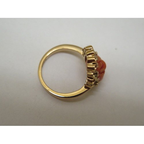 868 - A 22ct yellow gold ring with carved coral centrepiece, size N/O, approx 8.9 grams in good condition