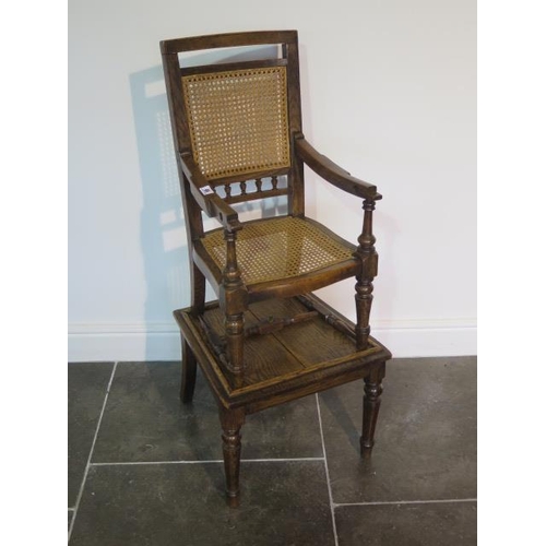 92 - A Victorian oak child's high chair on stand with Bergere cane seat and back, chair detaches from bas... 