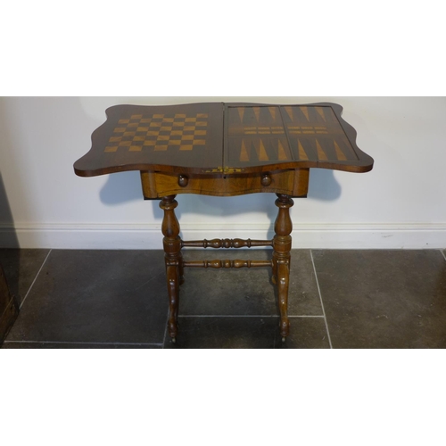 80 - A Victorian rosewood foldover top games worktable with games board top over a fitted drawer on turne... 