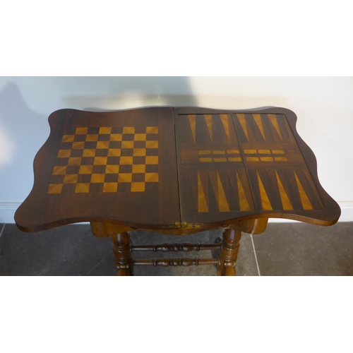 80 - A Victorian rosewood foldover top games worktable with games board top over a fitted drawer on turne... 