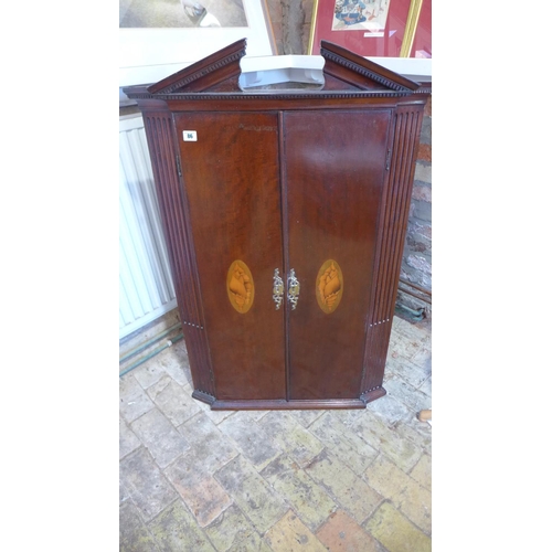 86 - A Georgian mahogany corner cupboard with two shell inlaid doors and a painted interior, 113cm tall x... 