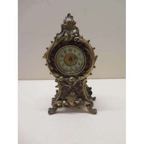 104 - A small clock made by The British United Clock Co Birmingham - tortoiseshell covering with brass dec... 