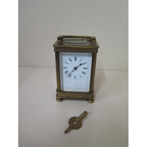 112 - A brass carriage clock with key - Height 13cm - one small chip to glass otherwise good