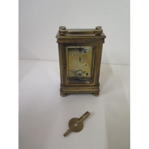 112 - A brass carriage clock with key - Height 13cm - one small chip to glass otherwise good