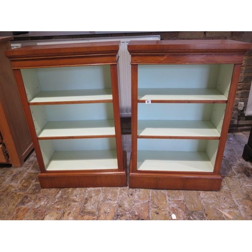 21 - A pair of walnut open bookcases with painted interior and adjustable shelves made by a local craftsm... 