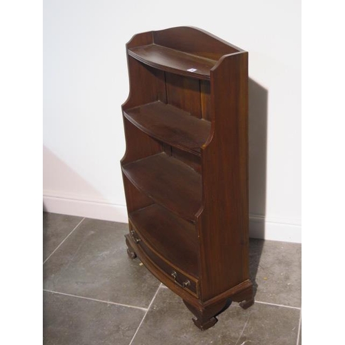 39 - A 20th century solid mahogany three shelf waterfall bow front bookcase with drawer below standing on... 