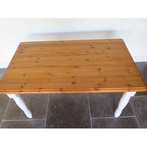43 - A pine kitchen table with painted turned leg base - height 76cm x 137cm x 81cm