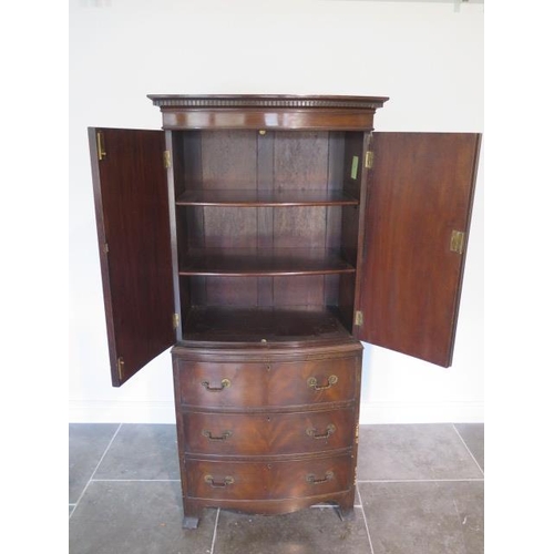 52 - A Georgian style mahogany bowfronted cupboard on three drawer chest - height 162cm x 70cm x 43cm
