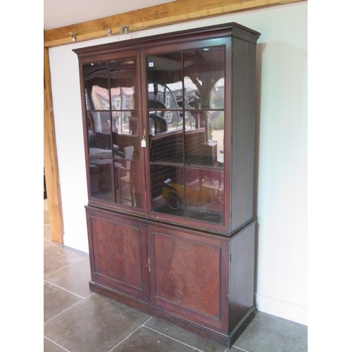 56 - A good Georgian mahogany bookcase on cupboard of small proportions with a two door glazed top over a... 