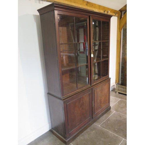 56 - A good Georgian mahogany bookcase on cupboard of small proportions with a two door glazed top over a... 