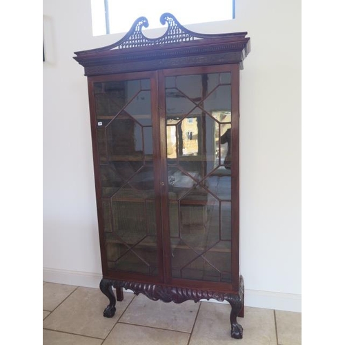 59 - A 19th century mahogany astragal glazed two door bookcase on an associated carved base and swan neck... 