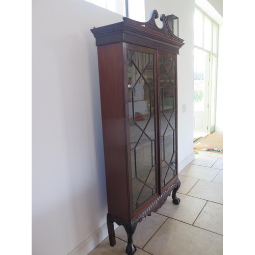 59 - A 19th century mahogany astragal glazed two door bookcase on an associated carved base and swan neck... 