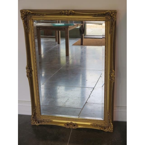 6 - An ornate gilt framed mirror - 91cm x 64cm