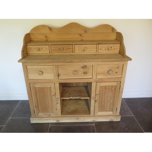 62 - A stripped pine dresser with a four drawer shaped top over three drawer and two cupboard doors - Hei... 