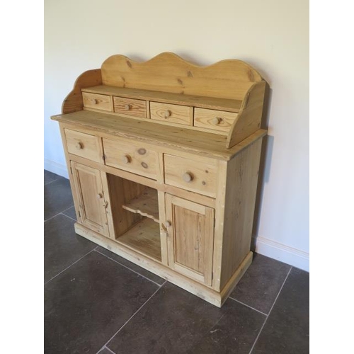 62 - A stripped pine dresser with a four drawer shaped top over three drawer and two cupboard doors - Hei... 