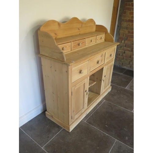 62 - A stripped pine dresser with a four drawer shaped top over three drawer and two cupboard doors - Hei... 