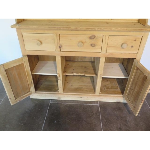 62 - A stripped pine dresser with a four drawer shaped top over three drawer and two cupboard doors - Hei... 