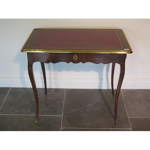 67 - A Continental side table with a leather inset top and a side drawer - height 72cm x 81cm x 49cm