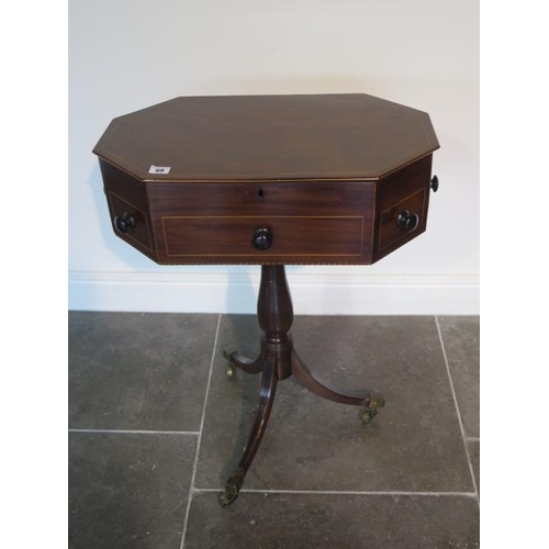 69 - An octagonal mahogany work table with two active drawers and a rising top on a turned column and tri... 