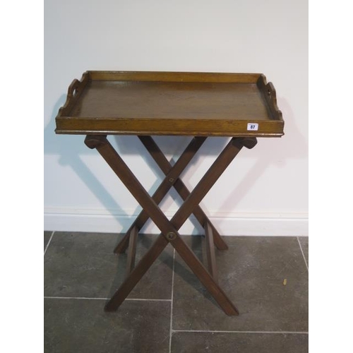 87 - An Edwardian/early 20th century oak butlers tray with X folding support - width 70cm x depth 47cm x ... 